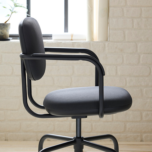 Silla de oficina moderna negra con diseño elegante, asiento y respaldo acolchados y altura ajustable, ubicada contra una pared de ladrillo.