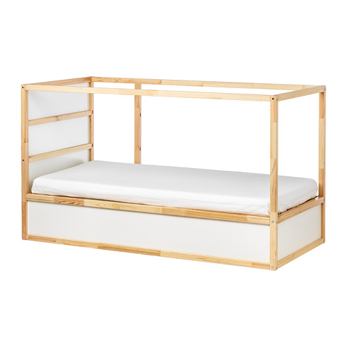 Una cama KURA de color madera clara con un colchón blanco, con un diseño minimalista y una estructura robusta.