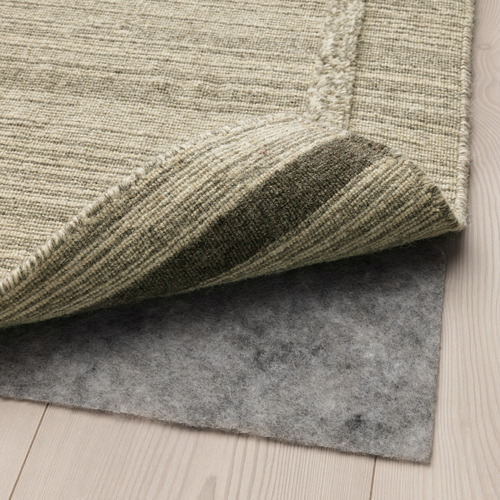 Base de alfombra con superficie antideslizante, que se muestra protegiendo el piso de madera.