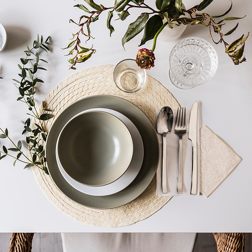 Elegante mesa con plato FÄRGKLAR, vegetación, cubiertos, cristalería, servilleta blanca.