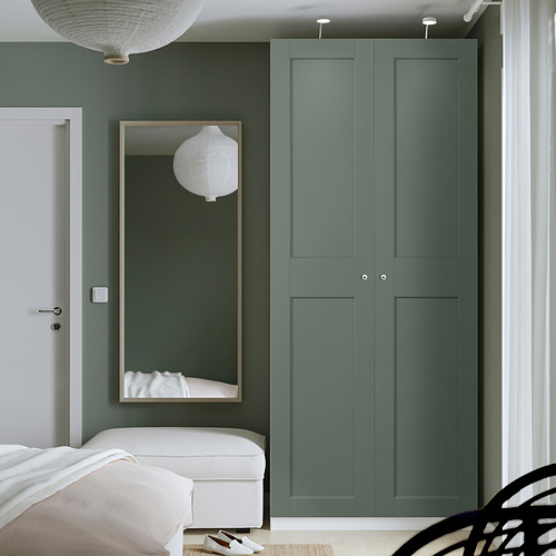 Dormitorio moderno con armario alto PAX verde turquesa. Cama blanca y espejo al lado.