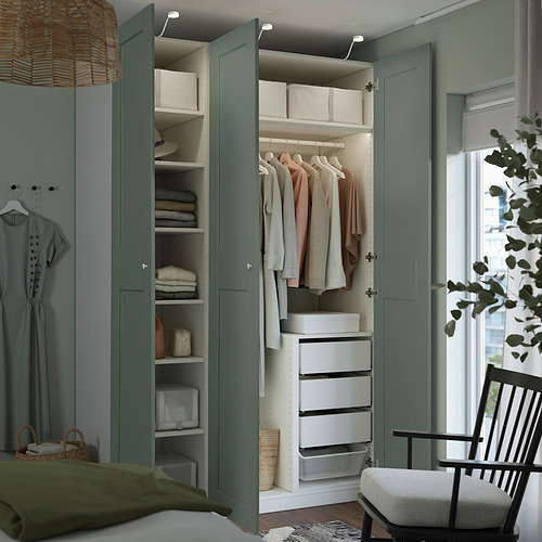Armario cerrado con acabado verde e interior blanco. Tiene estantes, cajones y una barra de ropa. La puerta tiene amortiguadores integrados para un cierre lento.