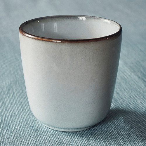 Taza de esmalte degradado en tela azul, bien elaborada con borde liso.