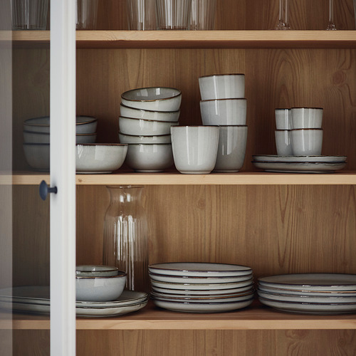 Cuencos, tazas y platos de gres en estantes de madera.