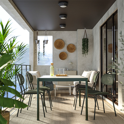 Moderno juego de comedor con balcón con mesa cuadrada, sillas apilables, plantas, cestas colgantes y arte de pared.
