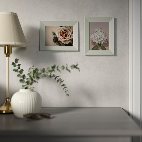 Una habitación moderna con fotos de flores y una lámpara.