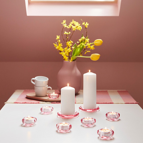 Portavelas de pétalos de flores rosas, velas blancas, jarrón de flores amarillas sobre estera a cuadros