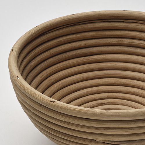 Primer plano de una cesta de prueba de ratán tejido, que muestra patrones intrincados y textura natural.