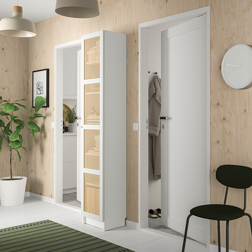 Entrada moderna con estantería blanca BILLY con puertas de bambú, silla negra, planta verde y paredes de madera.