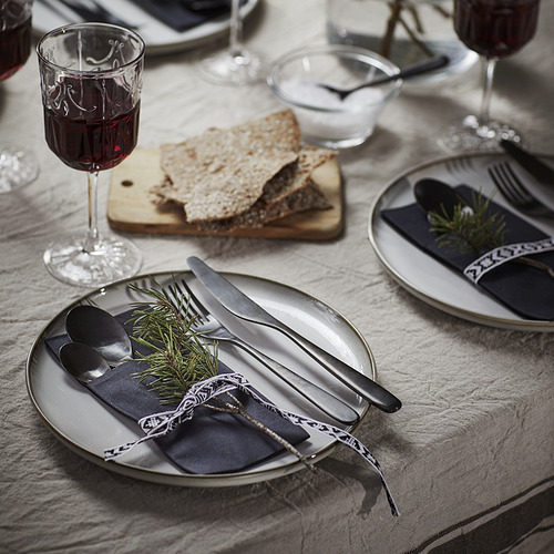 Mesa con servilletas MOTTAGA, cubiertos, copas de vino y rebanadas de pan.