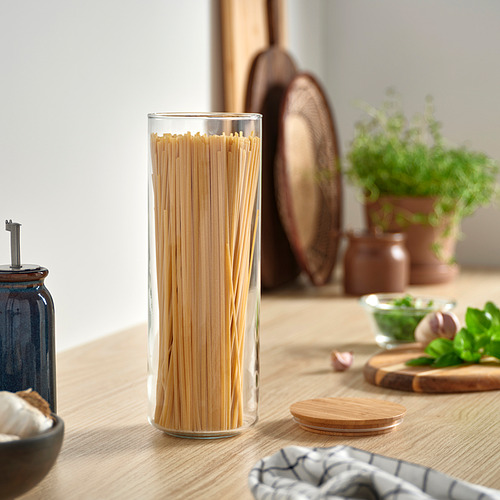Encimera de cocina con un tarro de cristal alto de espaguetis, tapa de bambú.