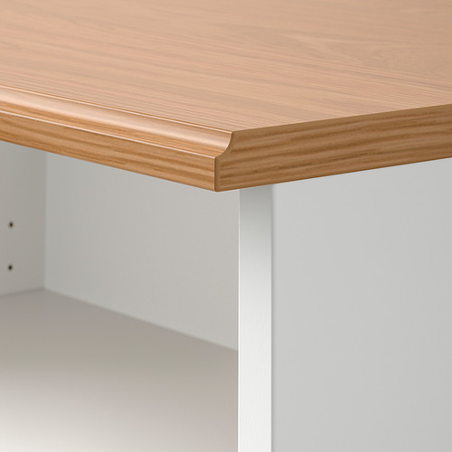 Primer plano de la mesa de madera de SKRUVBY, acabado liso y natural, bordes limpios, sobre un armario blanco.