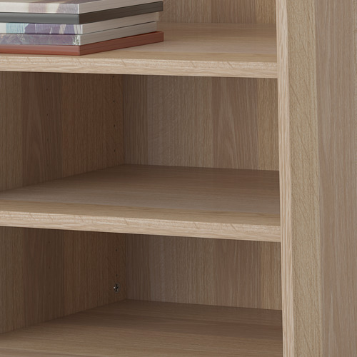 Estantería de madera con tres estantes vacíos y una pila de libros encima. Los estantes son ajustables.
