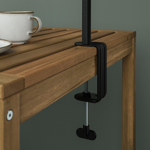 Mesa de madera sujeta con abrazadera negra, apta para uso en interiores o exteriores, con una taza en la parte superior, rango de sujeción de hasta 100 mm.