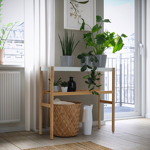 Soporte de plantas de madera con vegetación de varios niveles cerca de la ventana