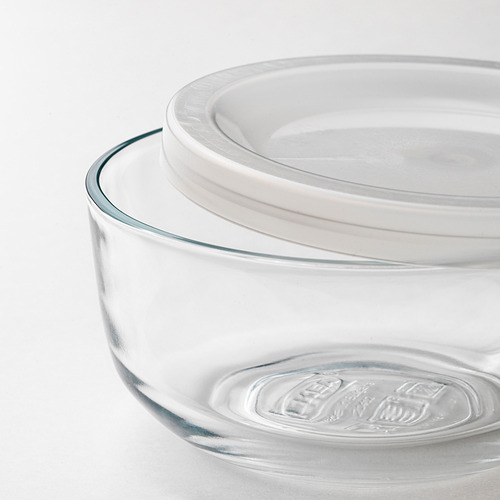 Recipiente de vidrio transparente para alimentos con tapa blanca, cuidadosamente apilado.
