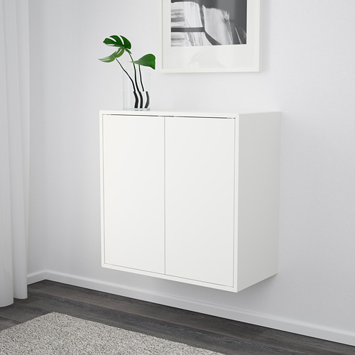 Armario de almacenamiento de pared blanco con dos puertas y una planta en maceta en la parte superior.