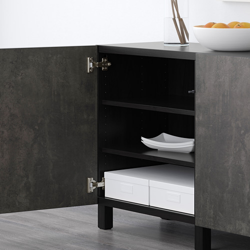 Armario de madera oscura con puerta abierta que deja ver estantes de almacenamiento y cajas blancas. Diseño moderno, estantes ajustables.