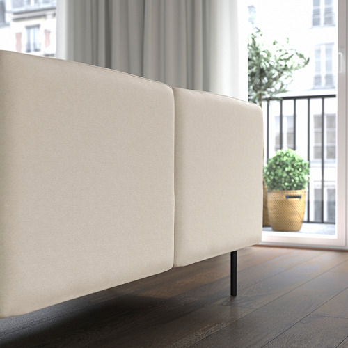 Minimalist cream sofa by window with plant.