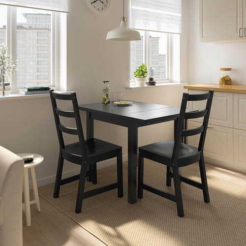 Moderno juego de comedor negro junto a la ventana con vista a la ciudad.
