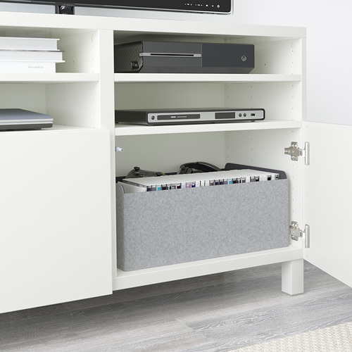 A BESTÅ tv bench with adjustable shelves, storing electronics and game systems. Cables are neatly managed with built-in outlets.