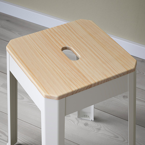 Taburete individual de madera con acabado claro, recorte redondo para el asa y patas de metal blanco. Diseño sencillo, robusto y funcional.