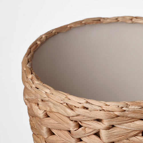Cesta tejida a mano, primer plano. Elaborado con jacinto de agua natural, con un tejido intrincado y una textura rústica.
