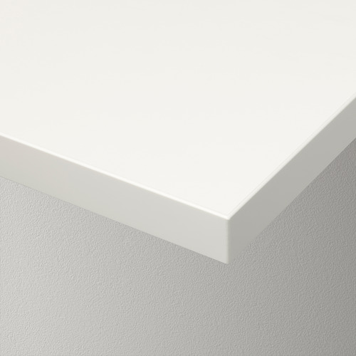 Primer plano de una elegante estantería de pared blanca con bordes lisos y biselados, montada en una pared lisa.