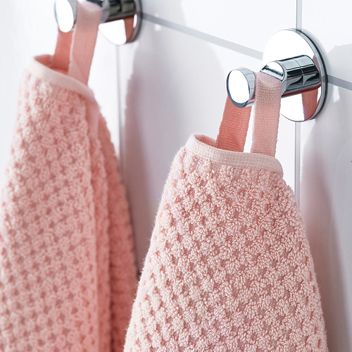 Dos toallas beige cuelgan de ganchos plateados, suaves y afelpados, ideales para usar en el baño.