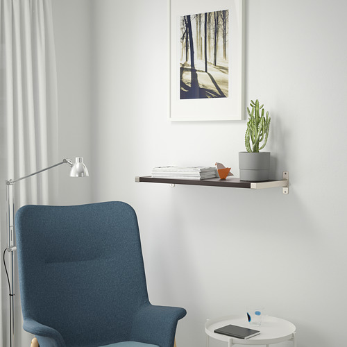 Oficina en casa minimalista con silla azul, mesa redonda, tableta, bolígrafo, estantería con libros, cactus y estampado de la naturaleza.