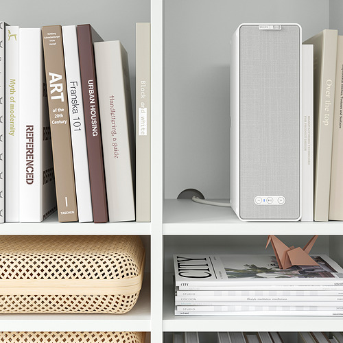 Estantería con altavoz blanco, libros y cestas; Decoración organizada.