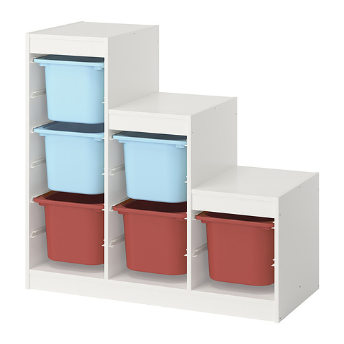 The TROFAST storage unit with blue and red plastic bins on white shelves. Its designed for children to organize their belongings.