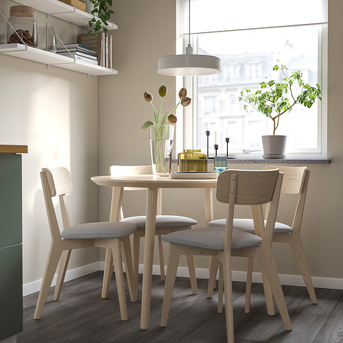 Comedor moderno con silla, mesa y decoración LISABO cerca de la ventana iluminada por el sol.