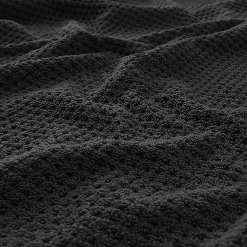 Toalla gris suave y afelpada en primer plano, que muestra su textura afelpada y su artesanía de calidad.