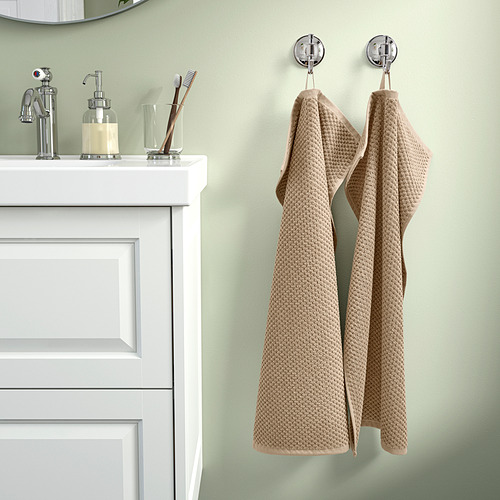 Baño limpio: toalla GULVIAL beige cuelga junto al lavabo blanco; Algodón suave, grosor medio.