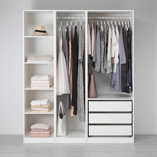 Armario minimalista con ropa, toallas y cajones de almacenamiento.