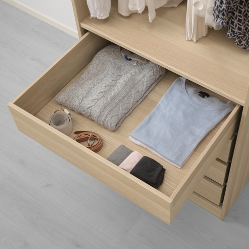 Cajón de madera abierto que muestra suéter, camisa, calcetines y accesorios doblados, lo que demuestra el almacenamiento organizado en un armario.