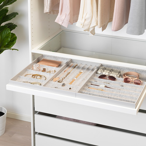 Un organizador de cajones blanco con compartimentos para joyas y accesorios. La bandeja se extrae para facilitar el acceso y se desliza hacia atrás en silencio.