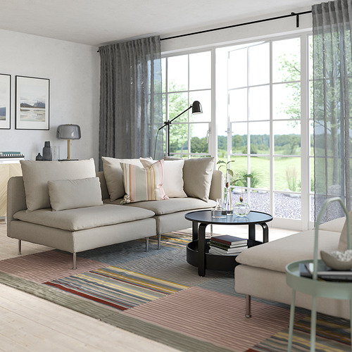 Modern living room a gray SÖDERHAMN sectional sofa with cushions, a black coffee table, and large windows with sheer curtains.