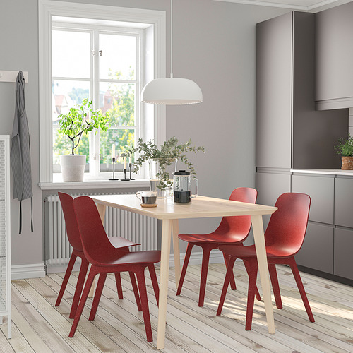 Pequeño juego de comedor moderno con mesa de madera clara y sillas rojas, diseñado para espacios acogedores.