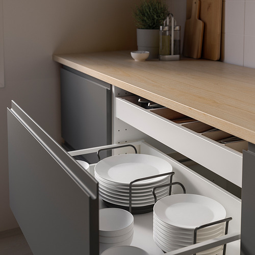 Estanterías de cocina con cajón abierto que muestran platos y cuencos blancos organizados, protegidos por soportes ajustables.