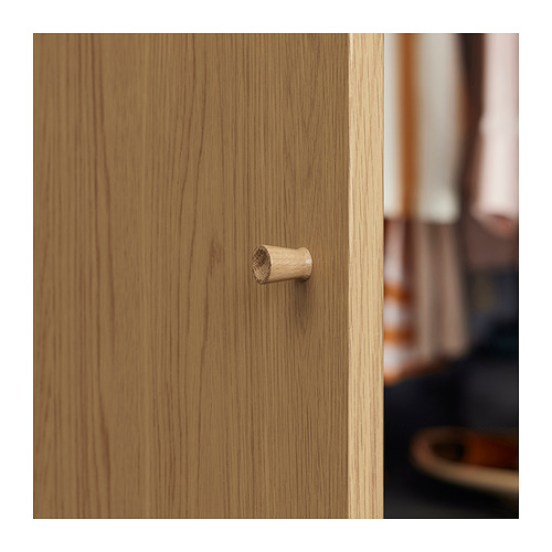 Pequeña clavija de madera sobre superficie de madera clara, detalle en primer plano.
