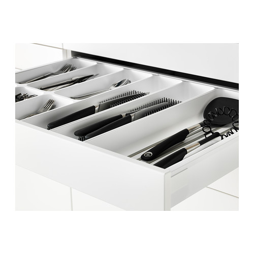 Cajón de cocina organizado con cubiertos y utensilios. Cajón blanco con múltiples compartimentos, función de cierre automático.