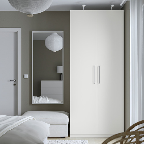Dormitorio minimalista con gran armario PAX, espejo y bisagras de cierre suave. Incluye cama con sábanas blancas, puerta y paredes grises.
