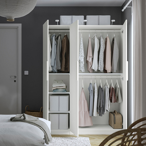 Open wardrobe with clothes, organized shelves, and storage boxes, showcasing interior organization.