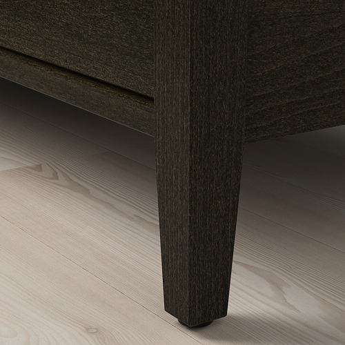Pata de mesa de madera oscura sobre suelo de madera clara. Acabado de alta calidad, diseño robusto.