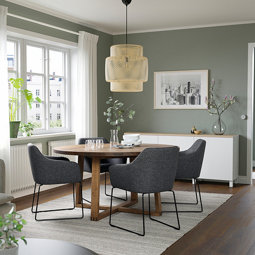 Comedor moderno con mesa de roble, sillas grises, lámpara colgante y paredes verdes. Compacto pero espacioso.