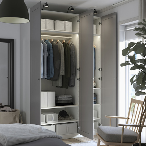 El armario moderno con puertas con espejos revela ropa organizada, estantes e iluminación. Armario, interiores ajustables y bisagras amortiguadas.