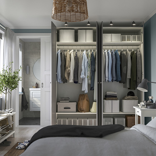 Dormitorio con armario PAX gris con ropa, estanterías, cajones e iluminación integrada.