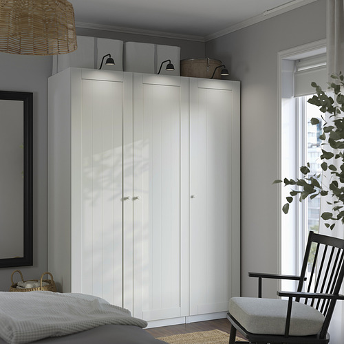 Dormitorio moderno con armario alto blanco, diseño minimalista, pared gris, apliques y vegetación.